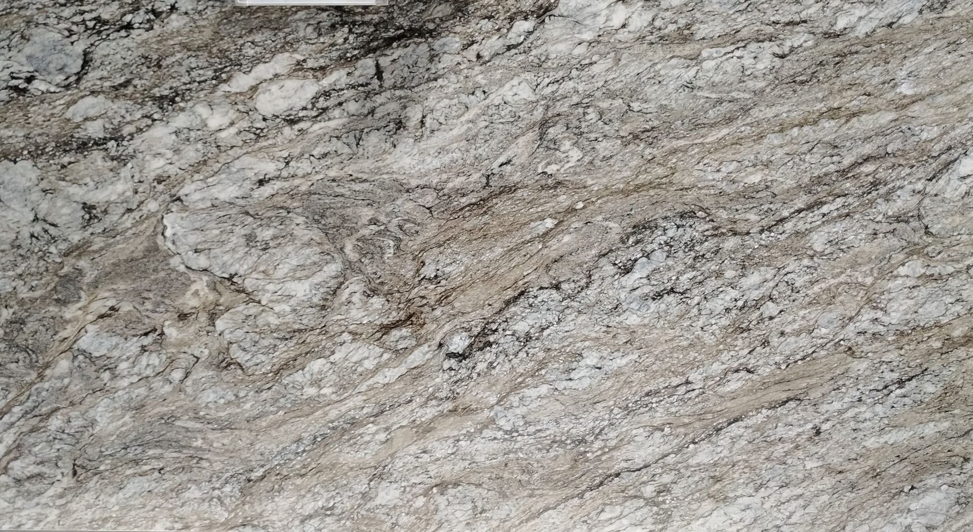 Close-up of a gray and beige stone surface with a rough, streaked texture.