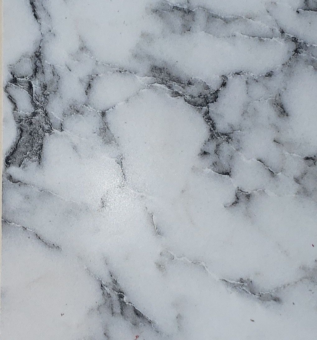 White and gray marble countertop with dark veining and soft cloudy patterns