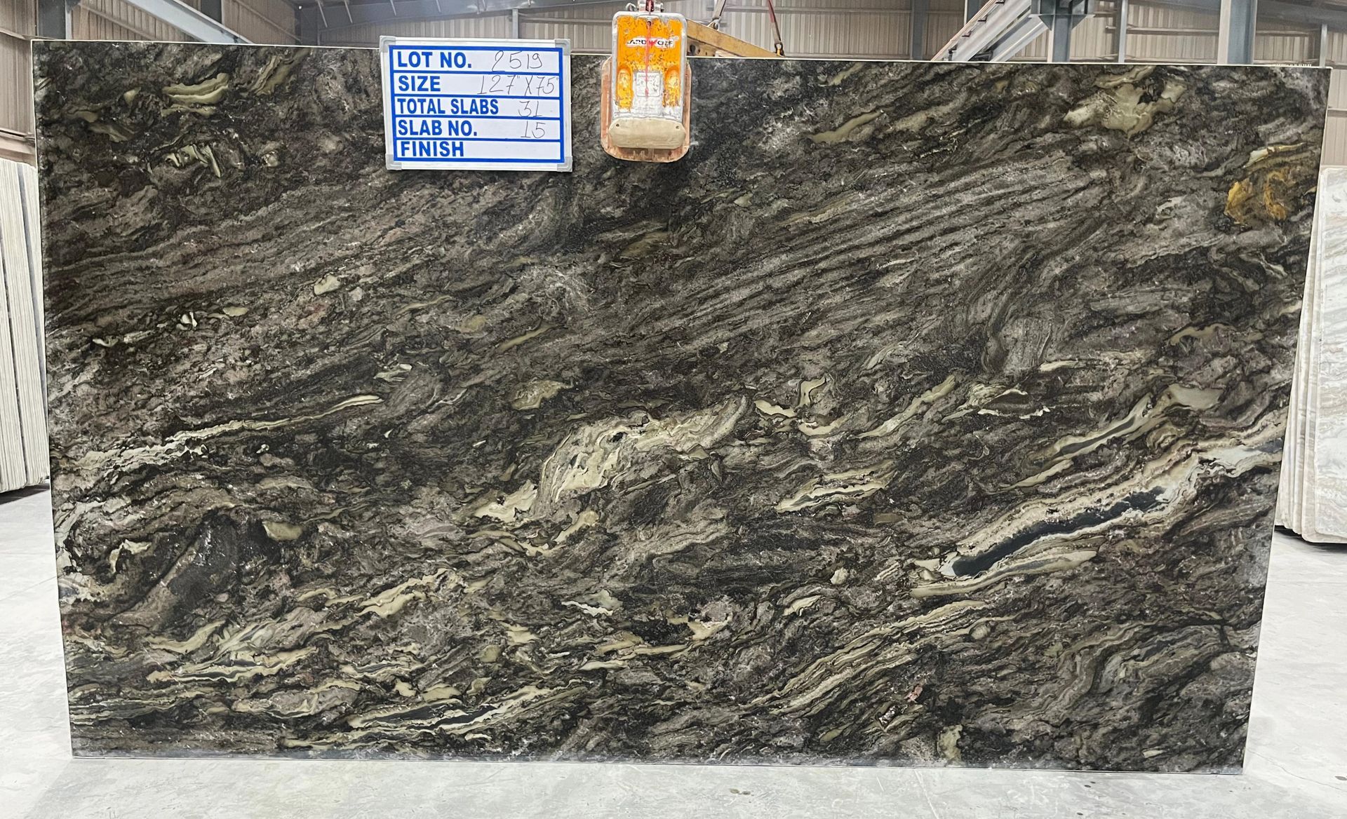 Dark gray veined stone slab with a blue label and orange tag at the top.