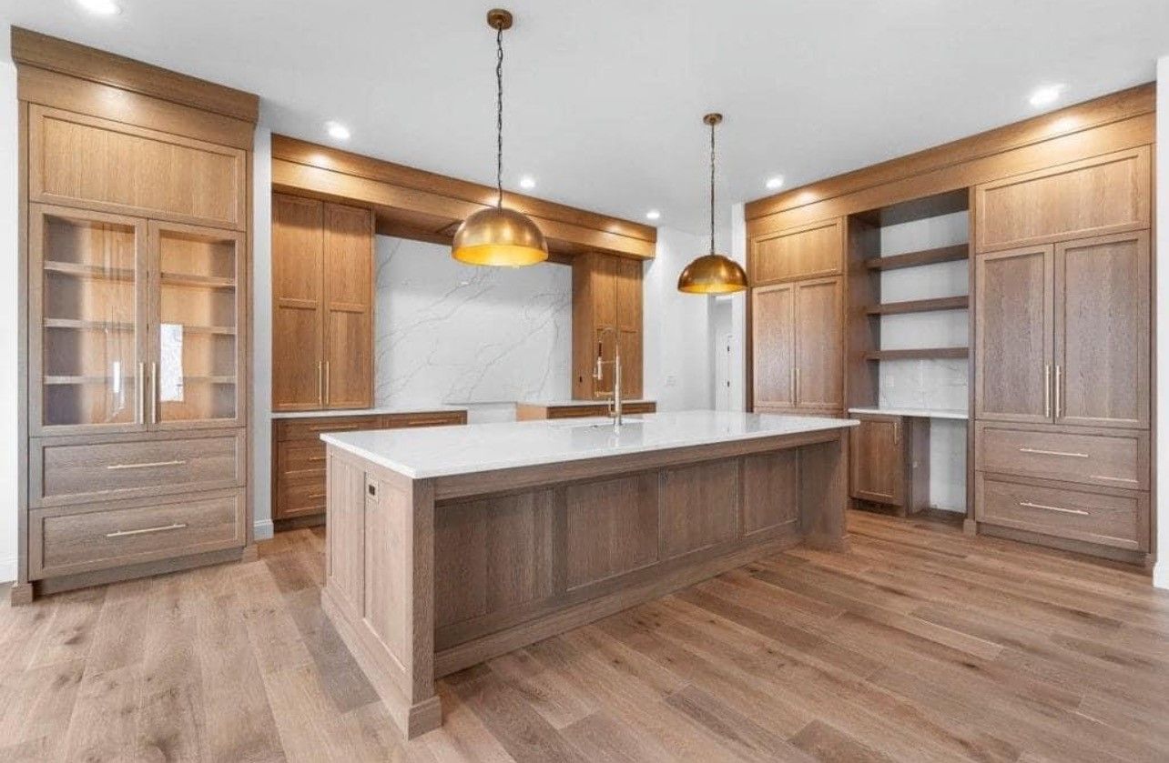 Modern kitchen with large island, light wood cabinetry, pendant lights, and open shelving
