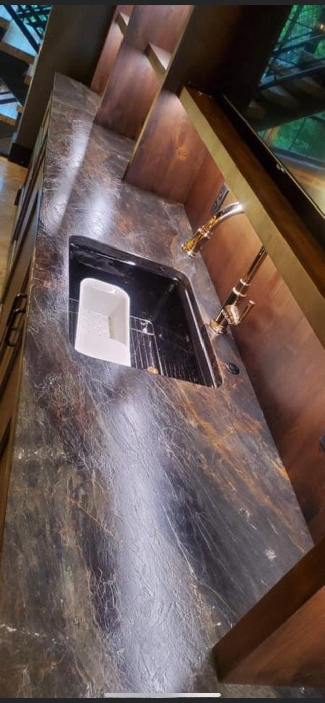 Modern staircase with a dark, glossy marble floor and wood-paneled walls, viewed from above.
