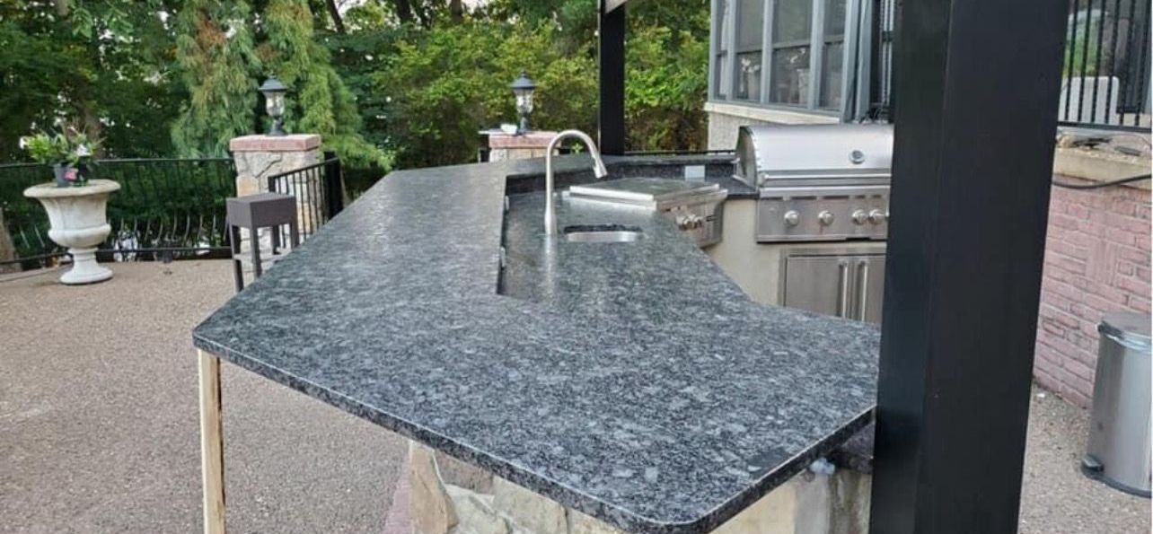 Granite outdoor countertop with built-in sink and faucet in a patio kitchen area