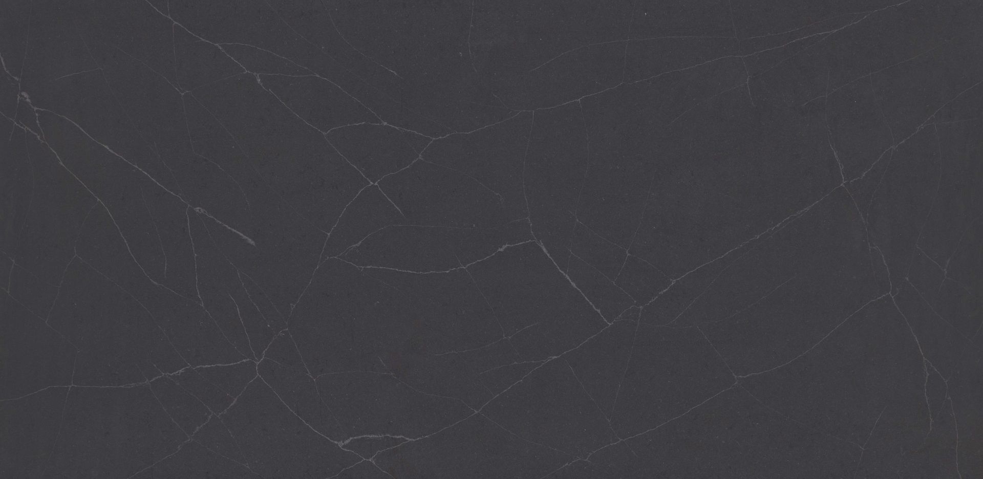 Dark gray scratched surface texture with faint white scuffs