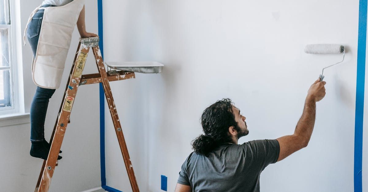 Painter applying a fresh coat of paint to an interior wall. Residential painting services for home improvement projects.