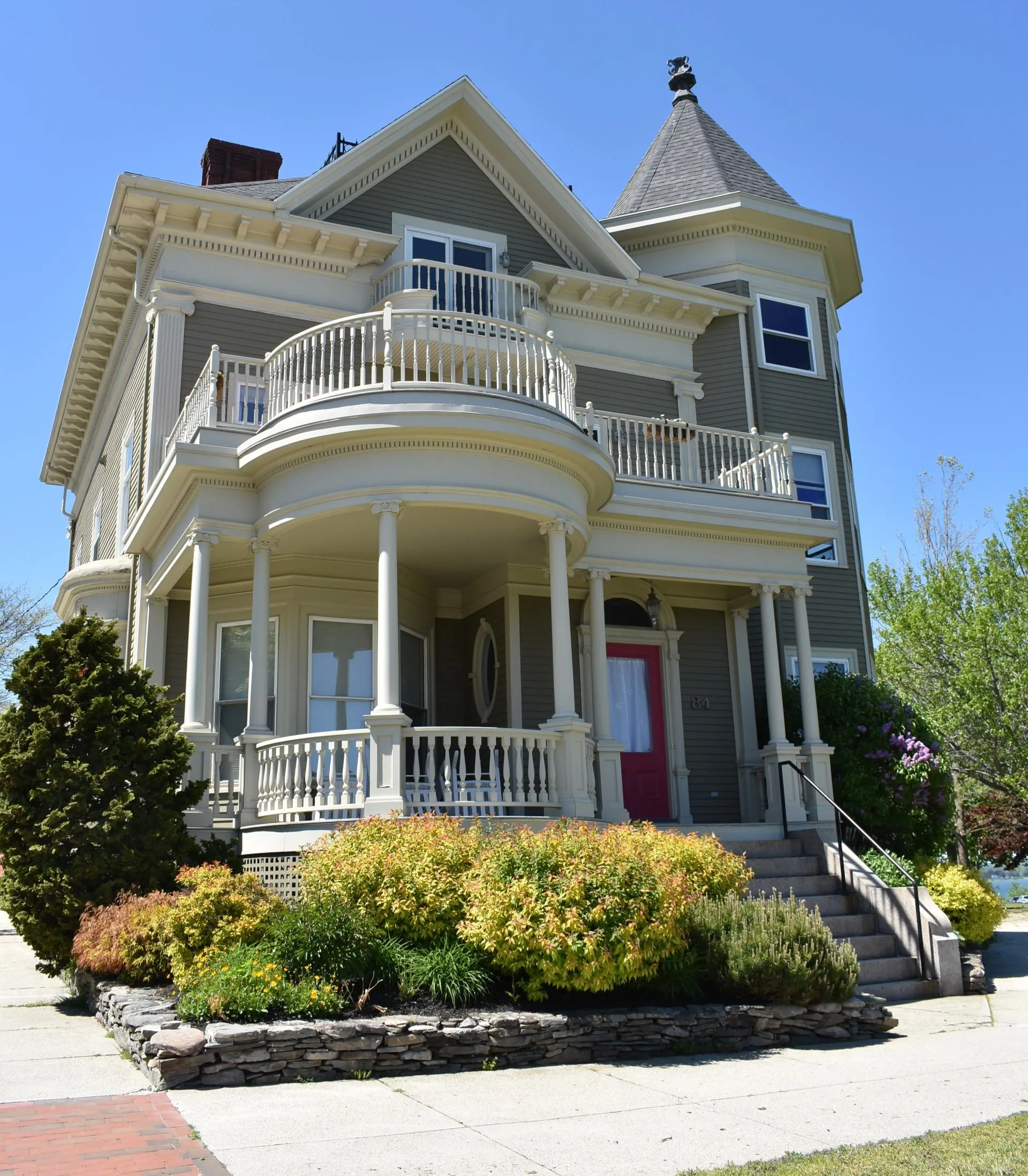 A large house with a large porch and a red door
