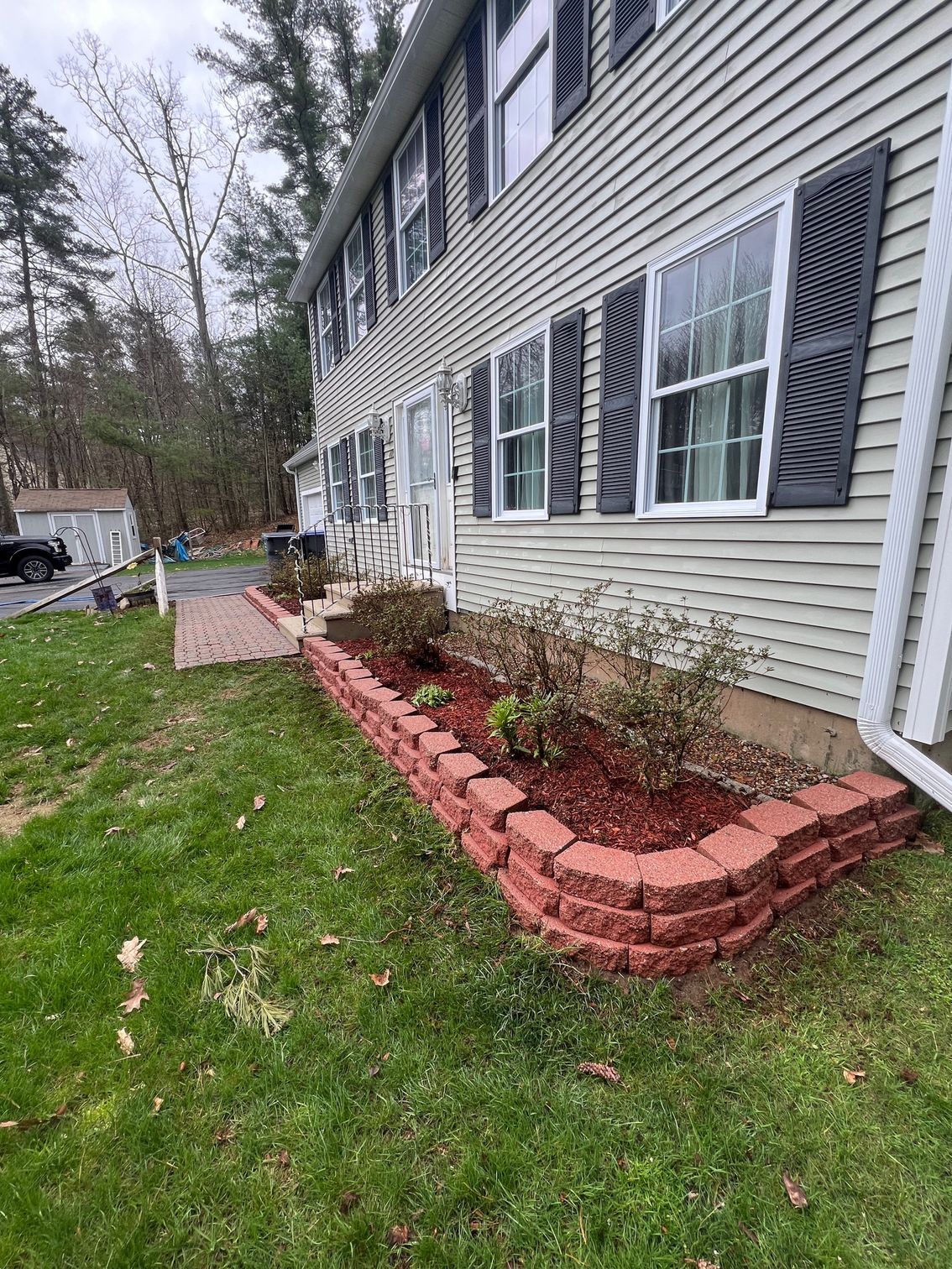 A house with a brick planter in front of it.