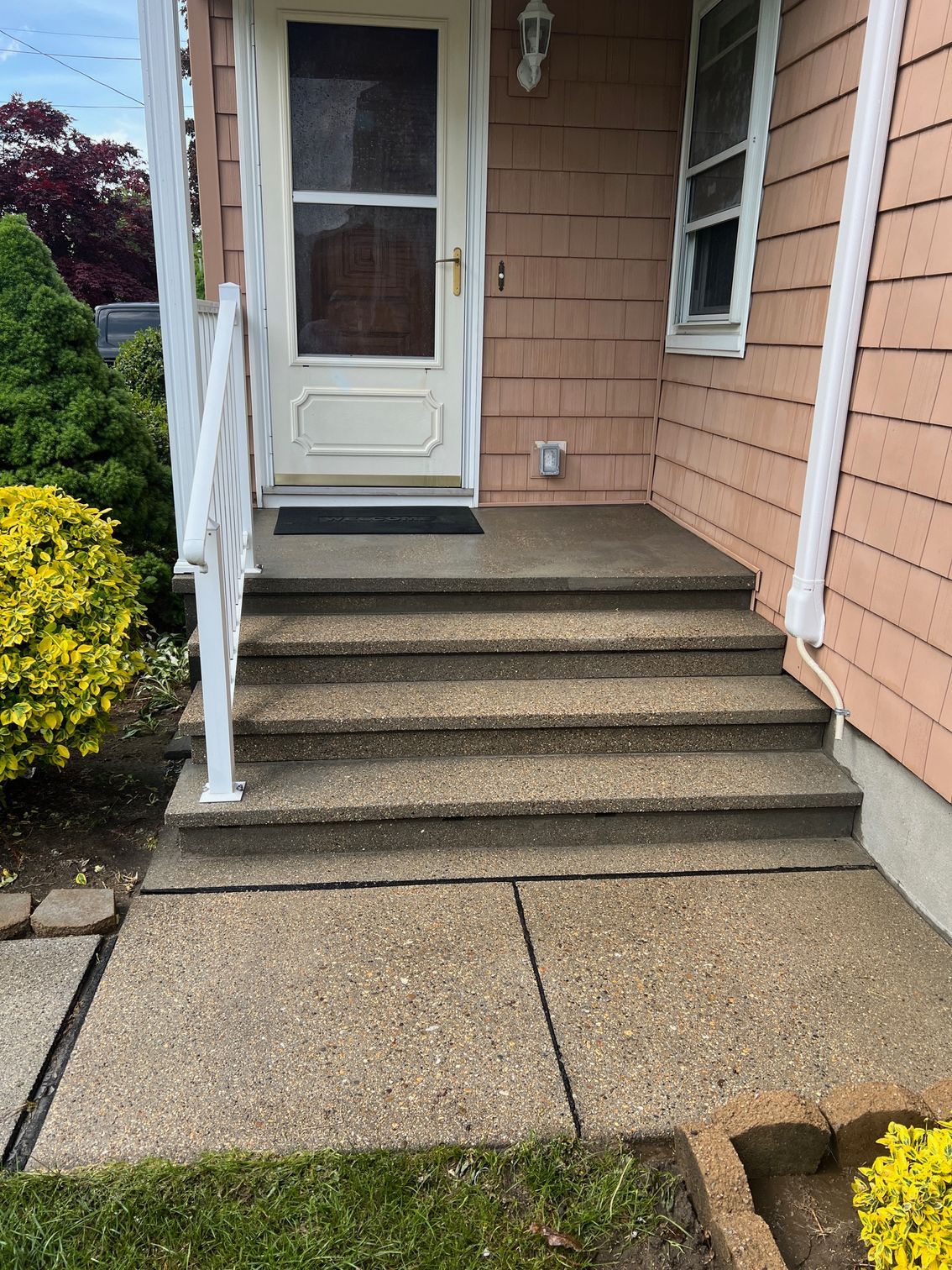 The front porch of a house with stairs leading up to it.