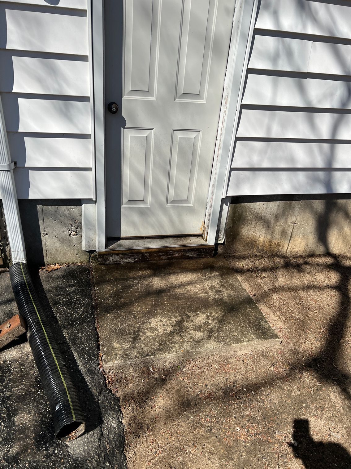 A white door is sitting on the side of a house.