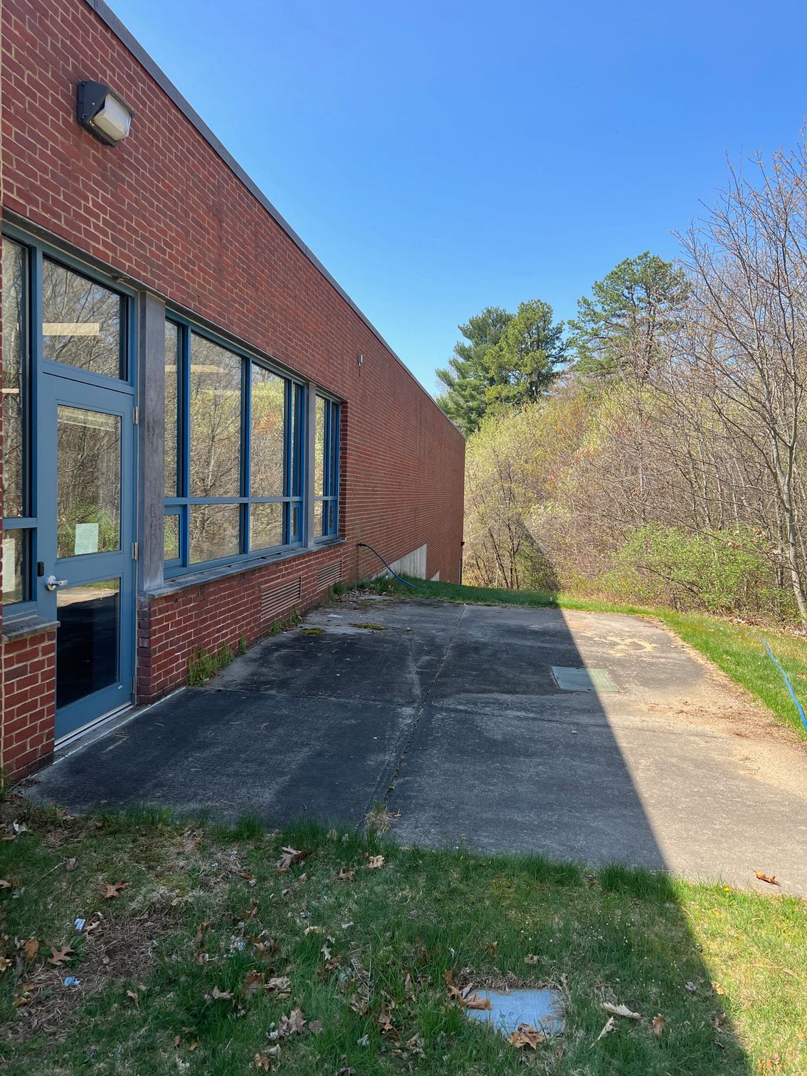 A brick building with a concrete walkway leading to it.