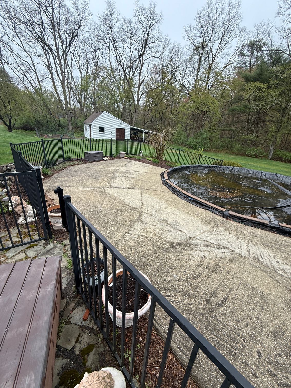 A patio with a pond and a house in the background.