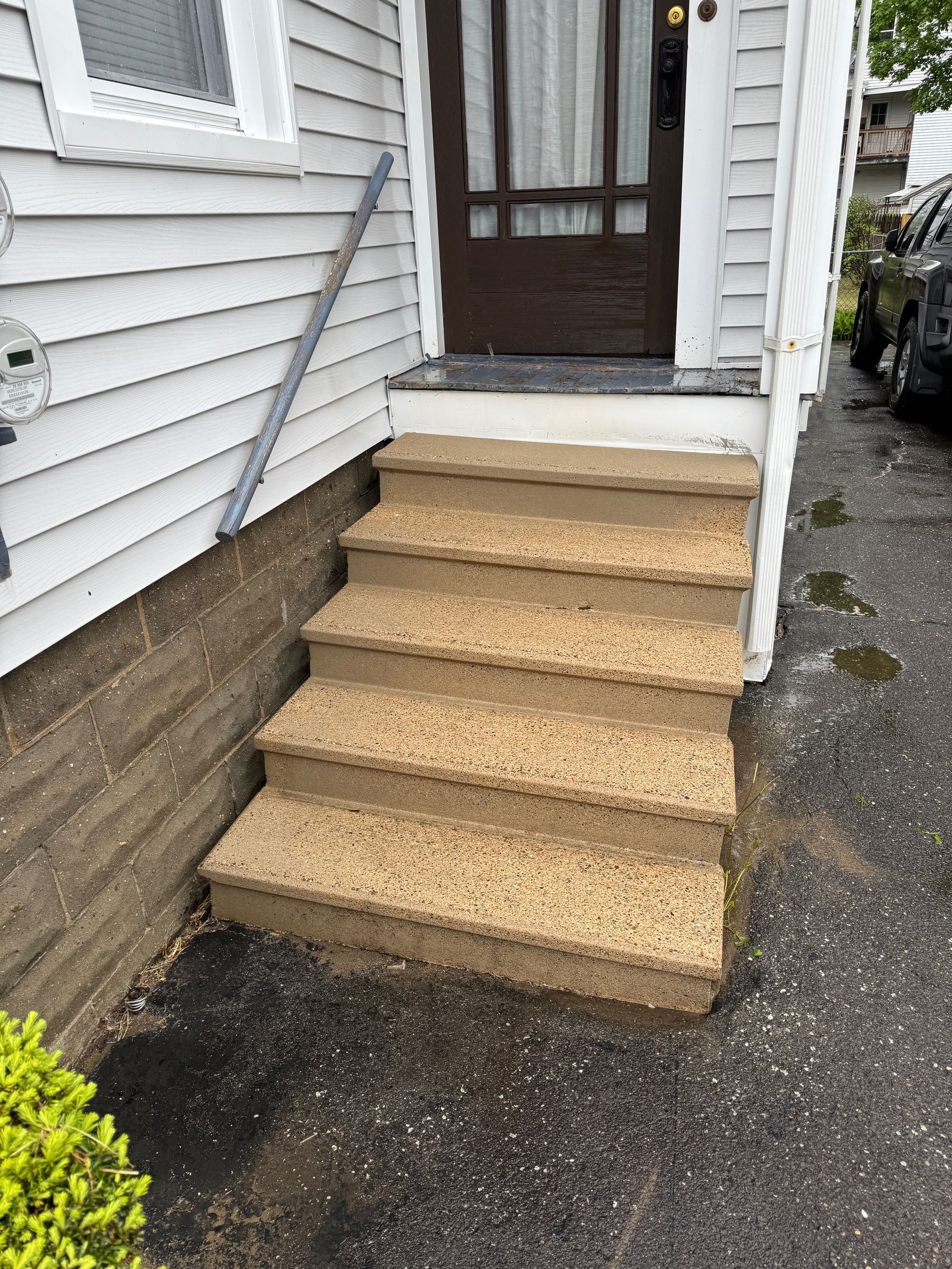 A set of stairs leading up to the front door of a house.