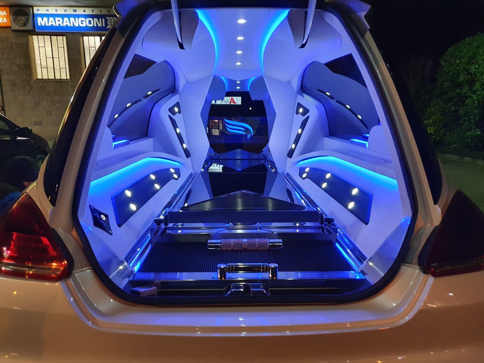 Apri il bagagliaio dell'auto con interni personalizzati illuminati a LED blu e sistema audio di notte