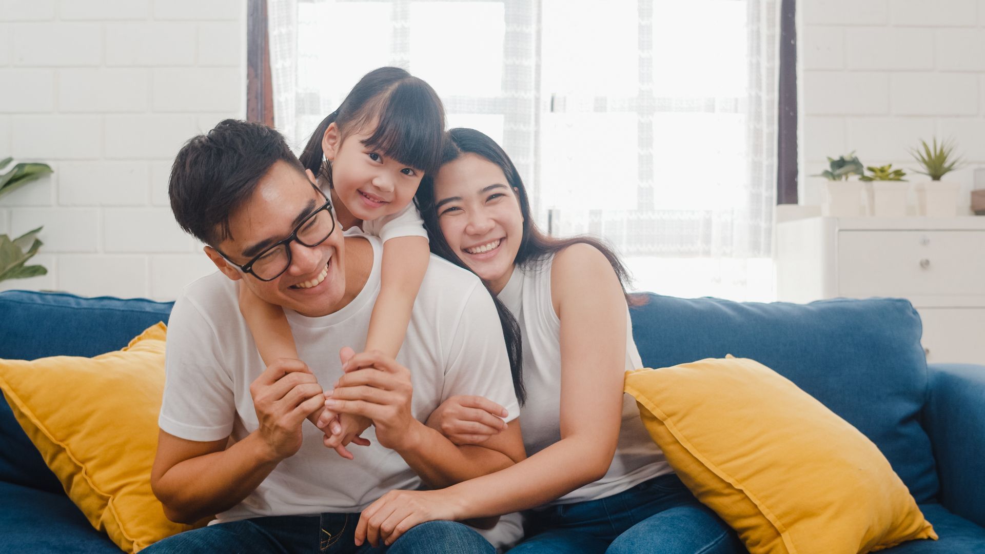 Smiling family hugging on a couch