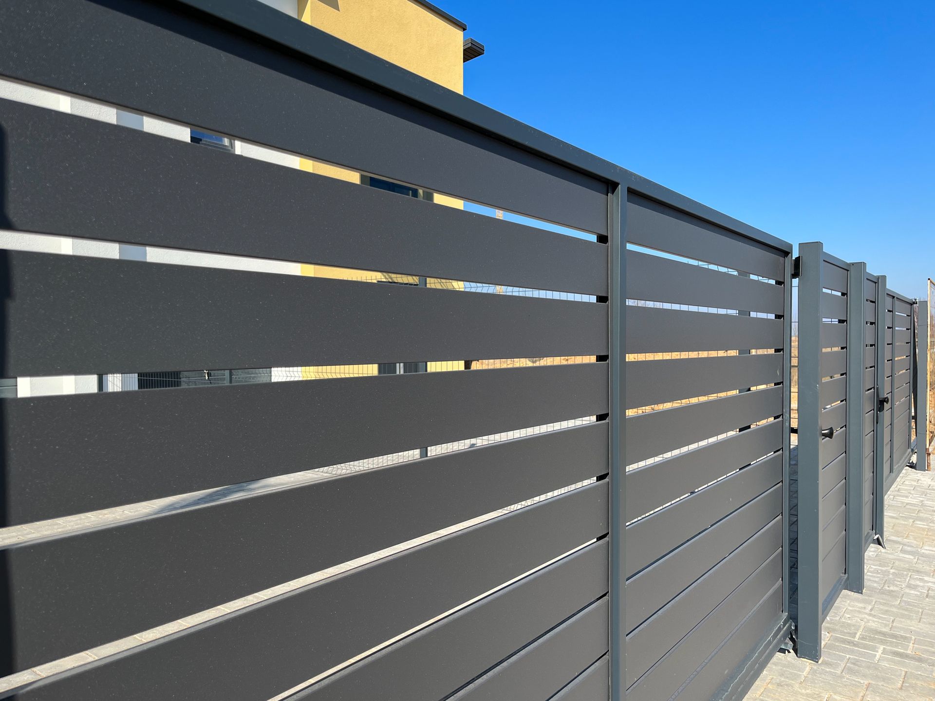 Modern, horizontal steel fence for fencing the yard area.