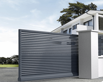 Gray automatic sliding gate in front of a modern white house, partially open.