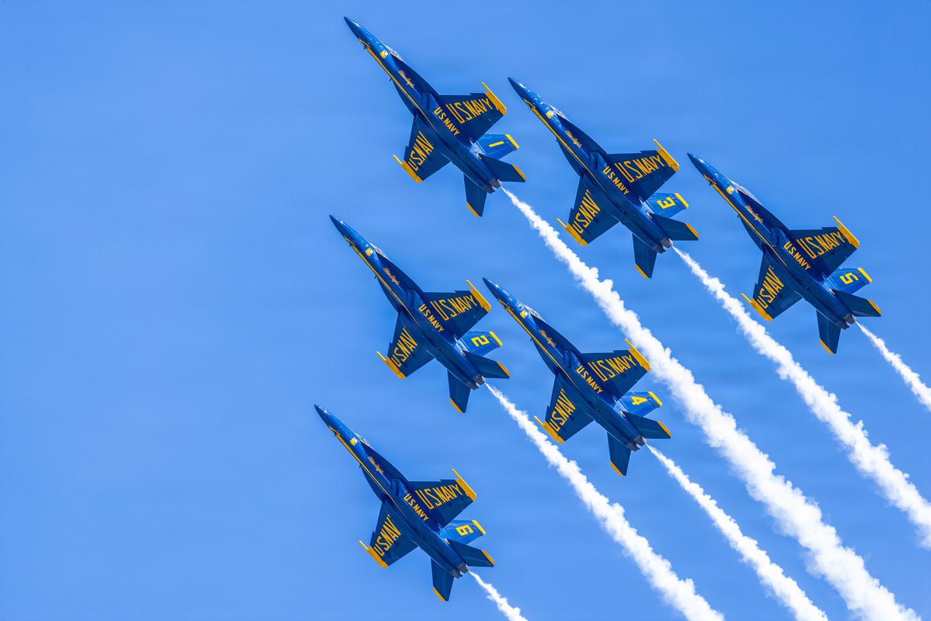 Four us navy fighter jets are flying in formation