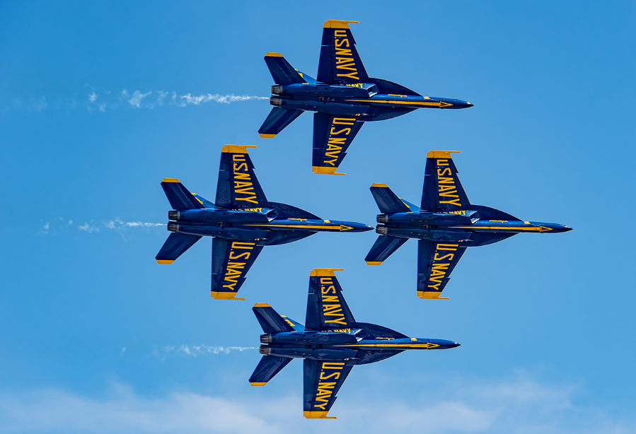 Four U.S. navy fighter jets are flying in formation