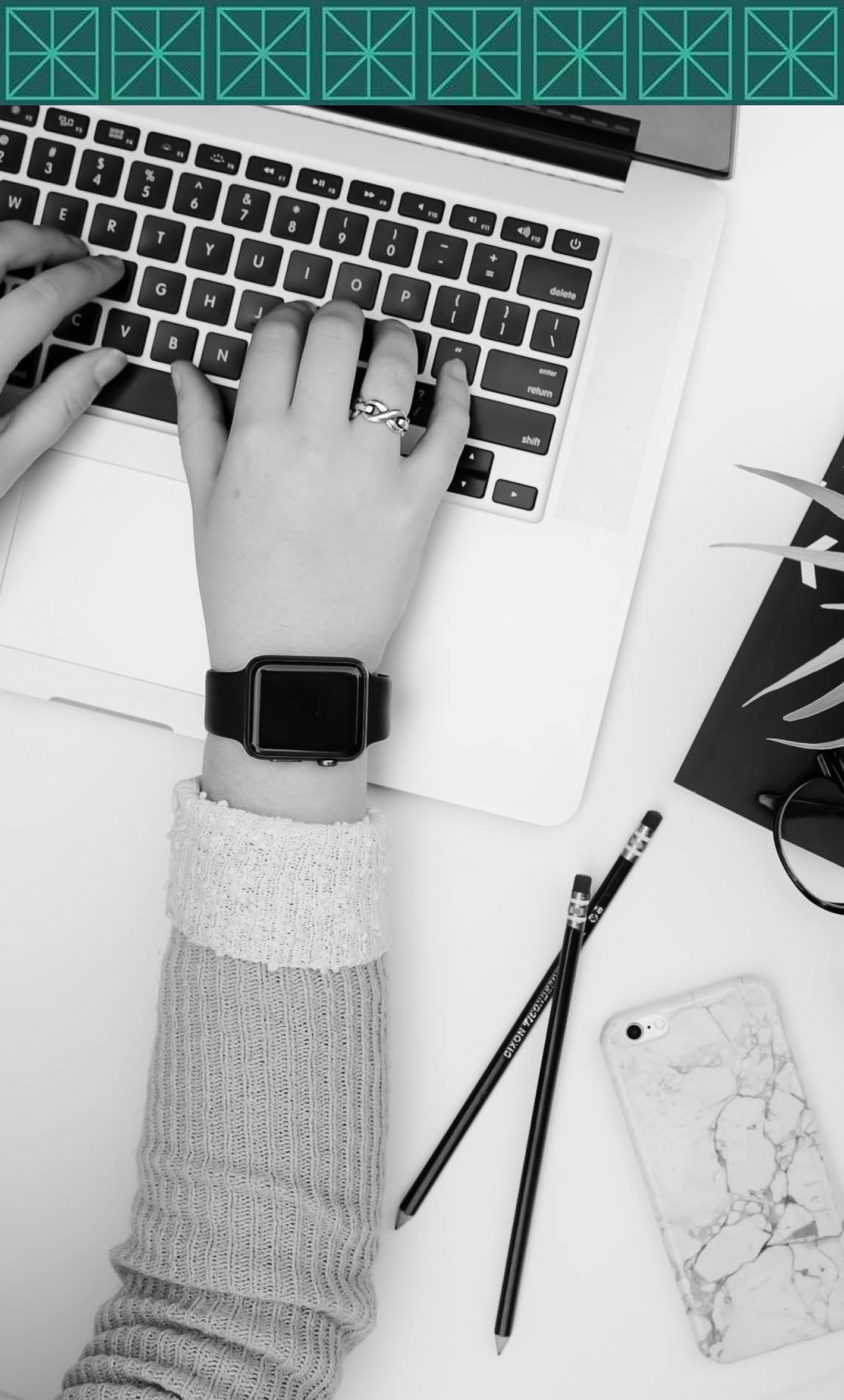 A person is typing on a laptop computer while wearing a watch.