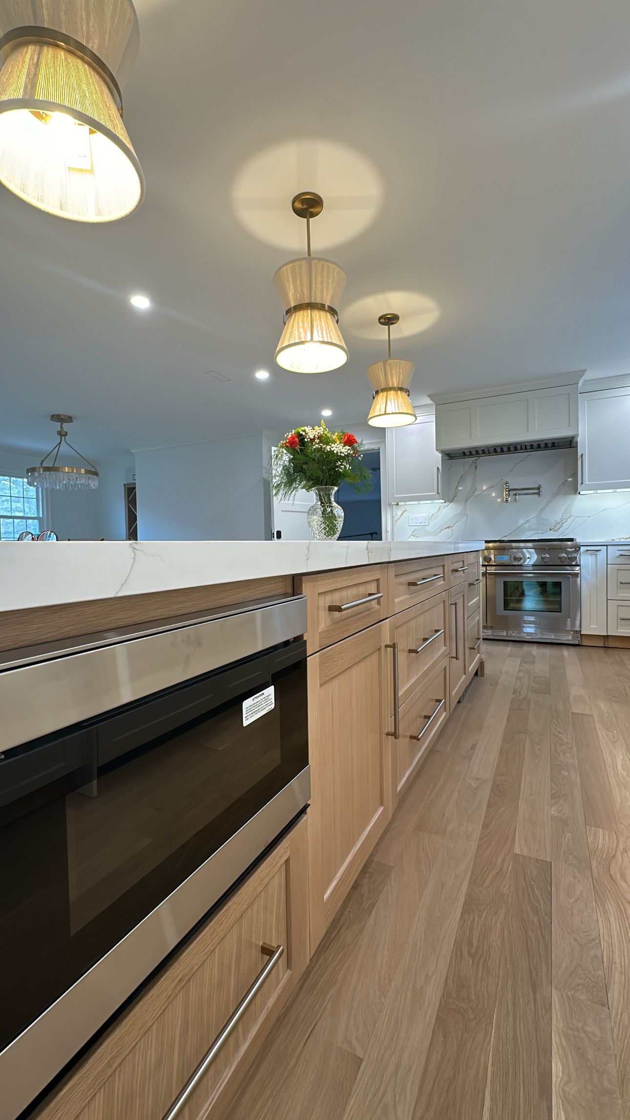 Kitchen with light wood cabinets, stainless steel appliances, and pendant lights.