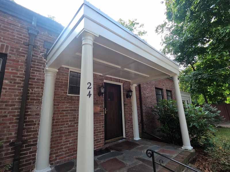 Brick house with white porch and pillars. The address, 