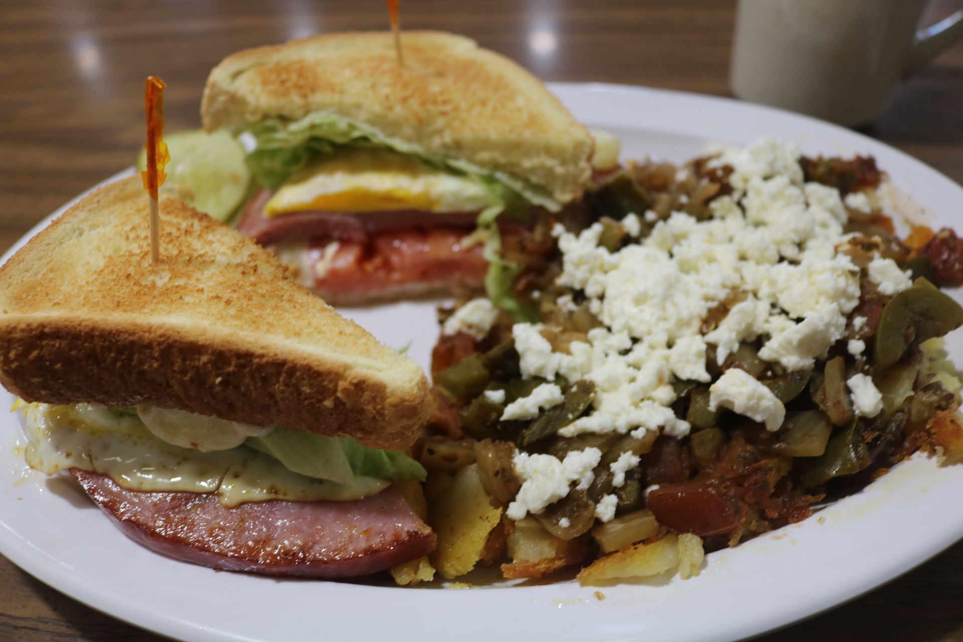 A plate of food with a sandwich and eggs on a table.