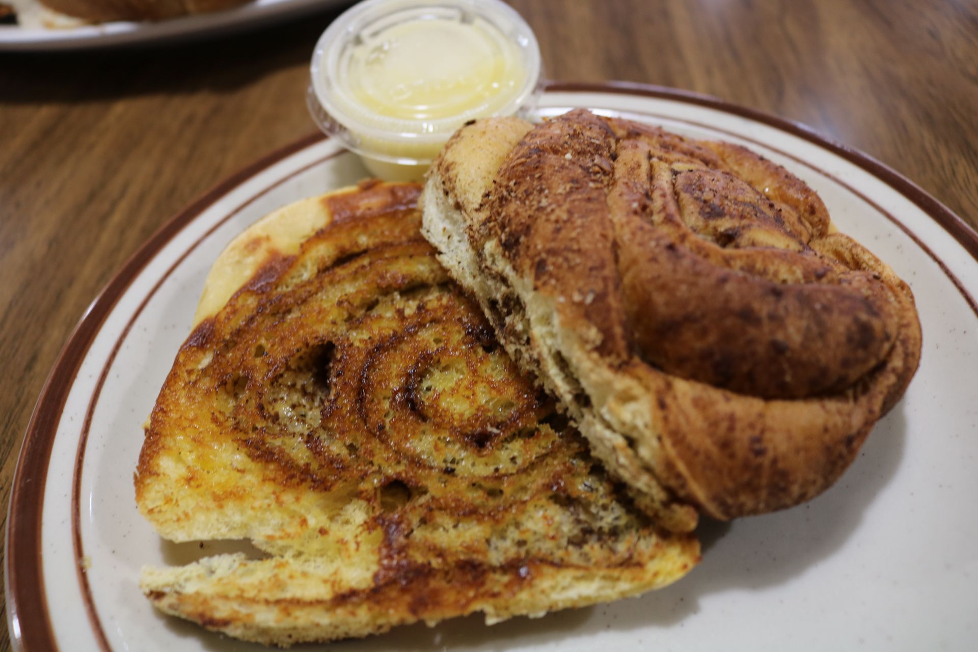 A close up of a cinnamon roll sandwich on a plate.