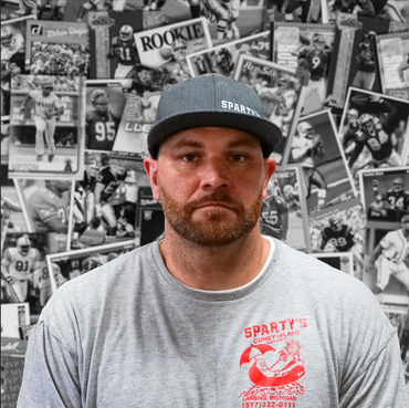 A man wearing a hat and a sparty 's shirt