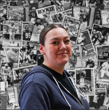 A woman stands in front of a wall with a collage of football players and the word rookie on it