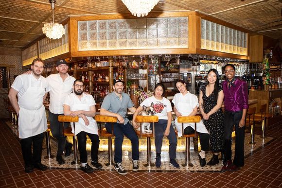 A group of people are posing for a picture in a restaurant.