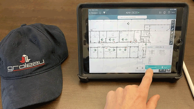Une main effleure une tablette affichant le plan de l'étage. Une casquette de baseball est posée à proximité.