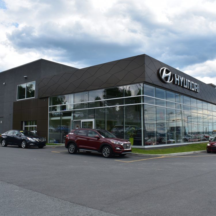 Extérieur d'une concession Hyundai avec des voitures garées.