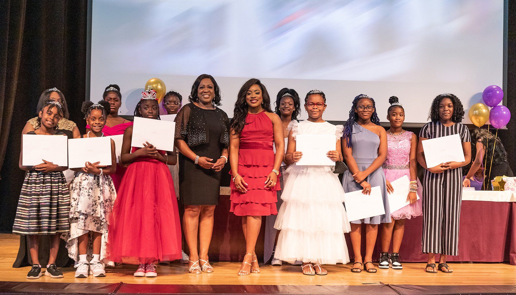a group of girls are posing for a picture on a stage