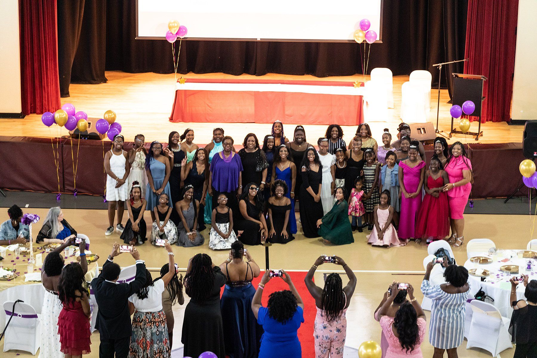a group of women are posing for a picture in front of a stage