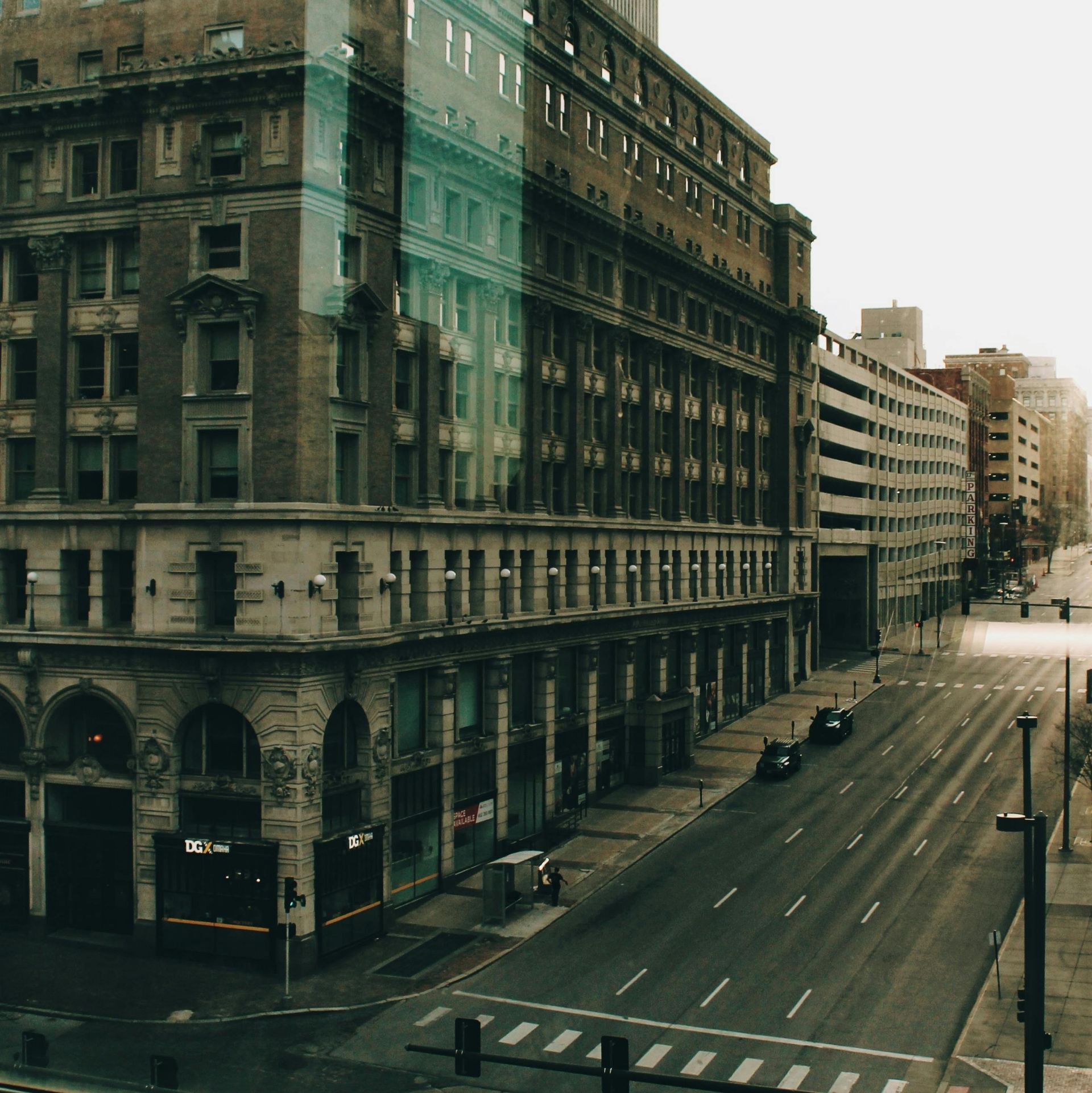 An aerial view of a city street with a large building in the background