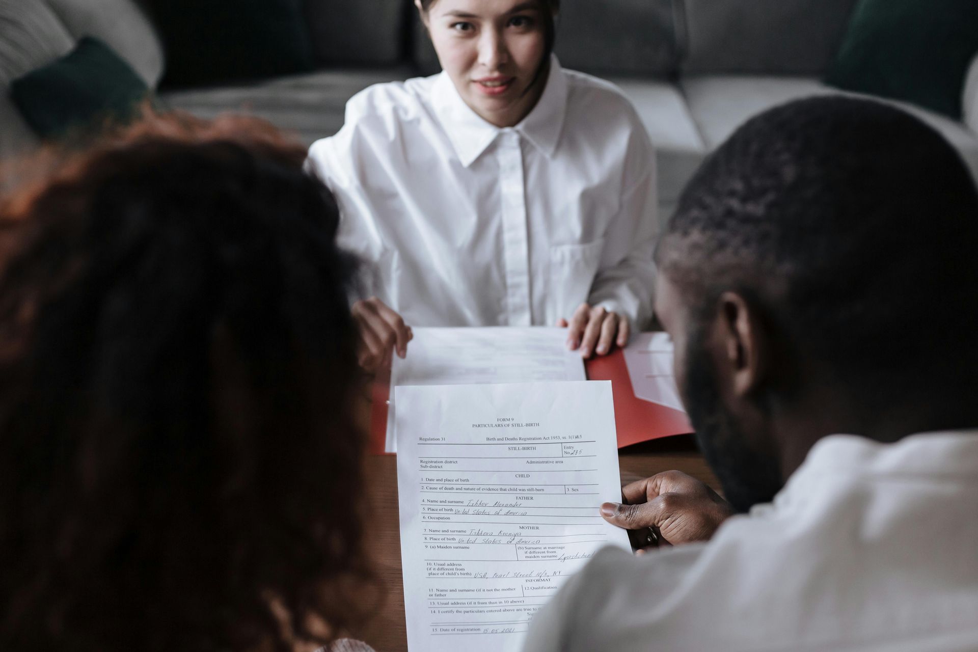 A man and a woman are sitting at a table looking at a piece of paper.