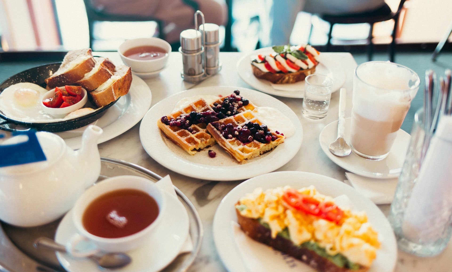 A table topped with plates of food and a cup of tea.