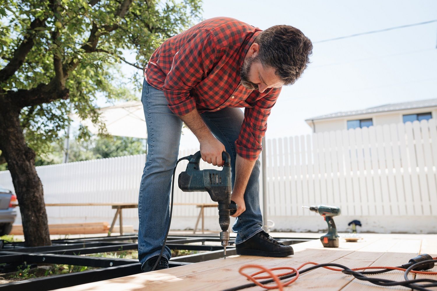 A man in Denver, CO, skilfully using a drill for deck building, showcasing craftsmanship and home im