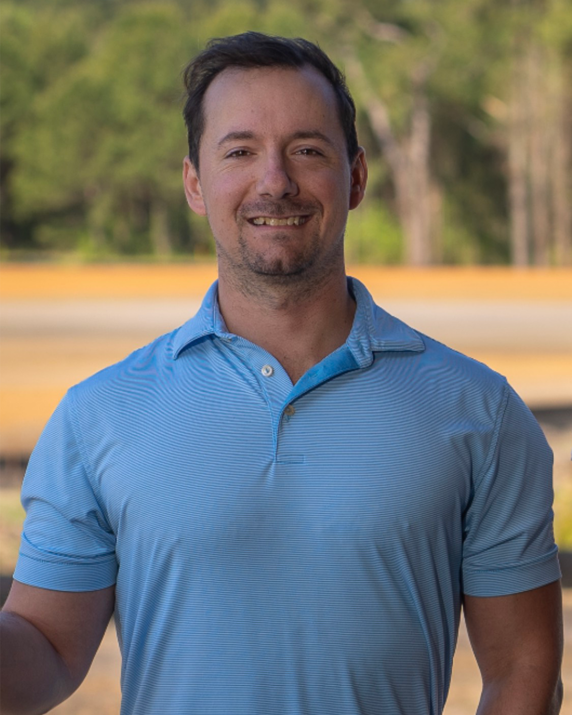A man wearing a white hat and a blue shirt is smiling for the camera.