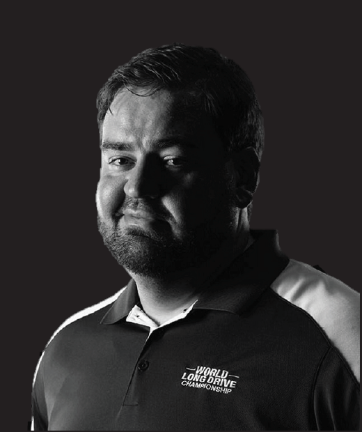 A man with a beard is wearing a black and white polo shirt.