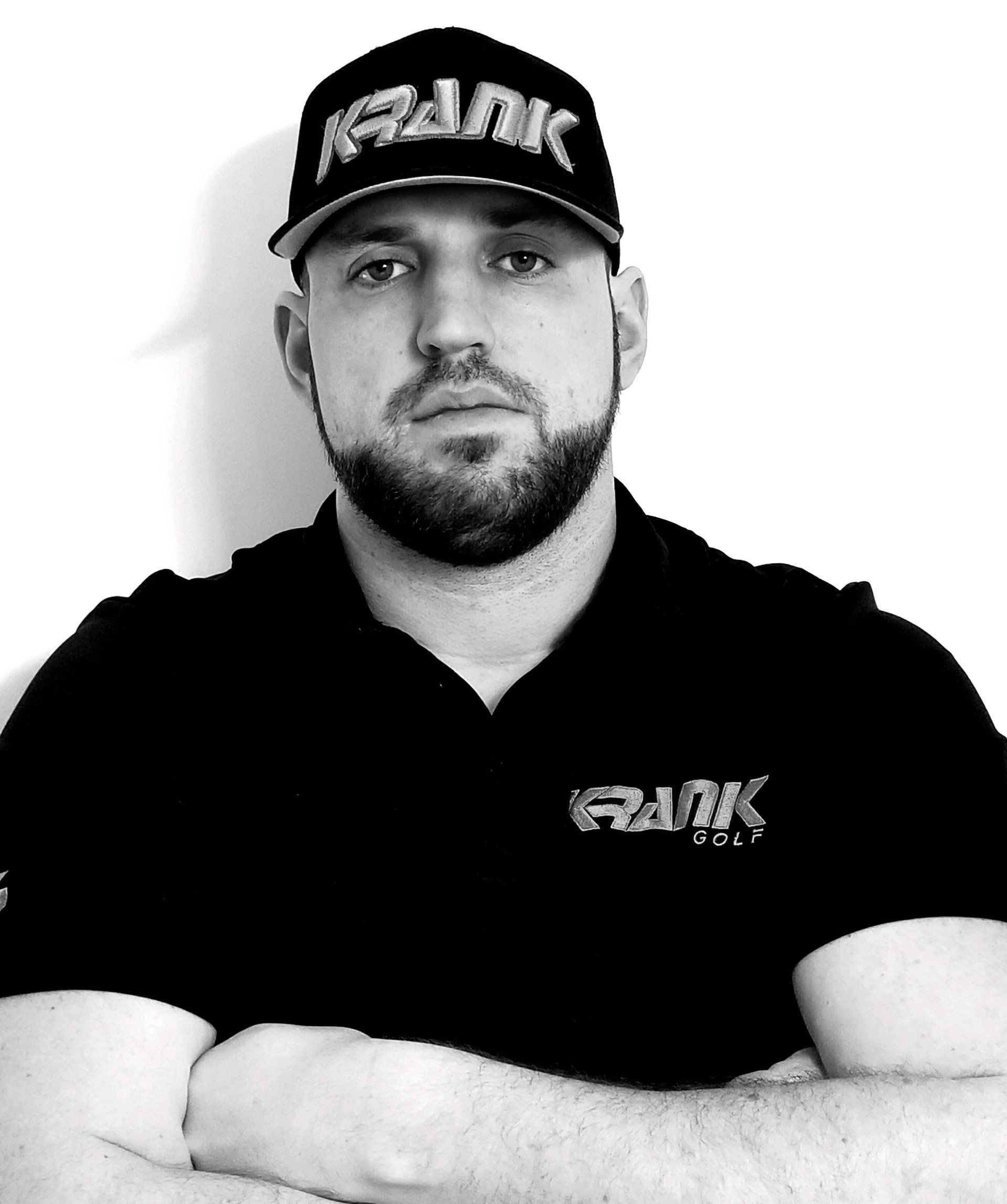 A man with a beard wearing a hat that says rank on it