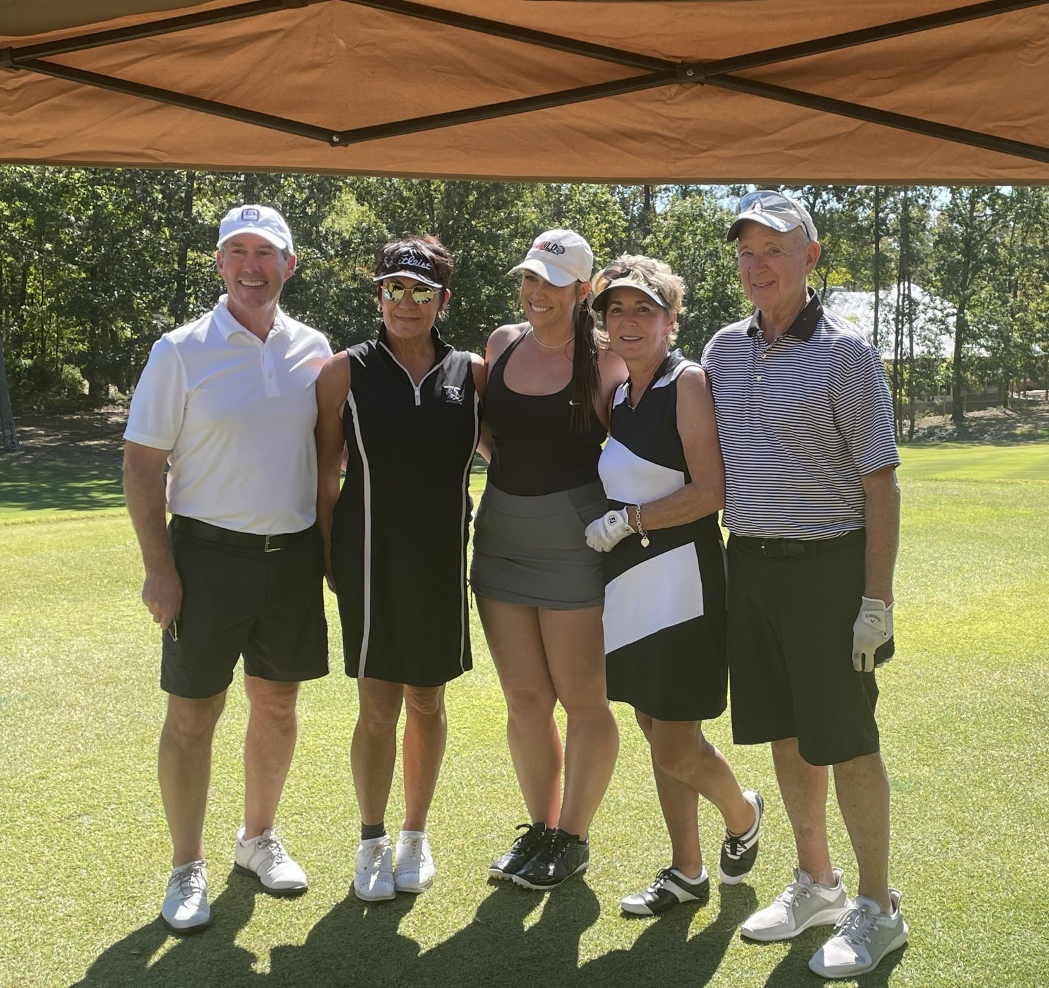 A group of people posing for a picture on a golf course