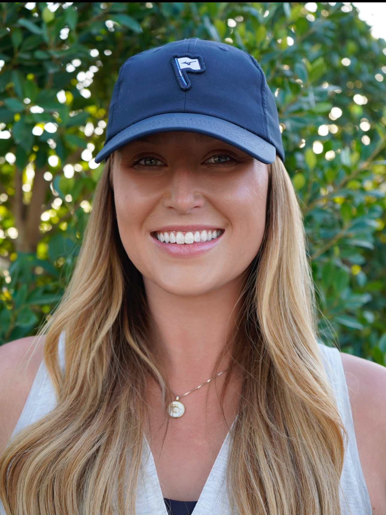 A woman wearing a baseball cap with the letter f on it