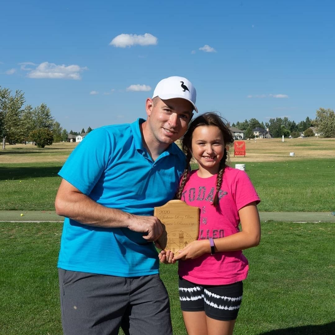 A man in a blue shirt and a girl in a pink shirt are posing for a picture