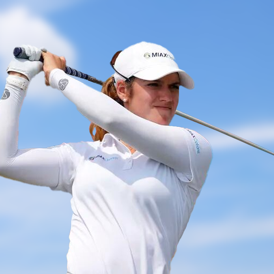 A woman wearing a max hat swings a golf club
