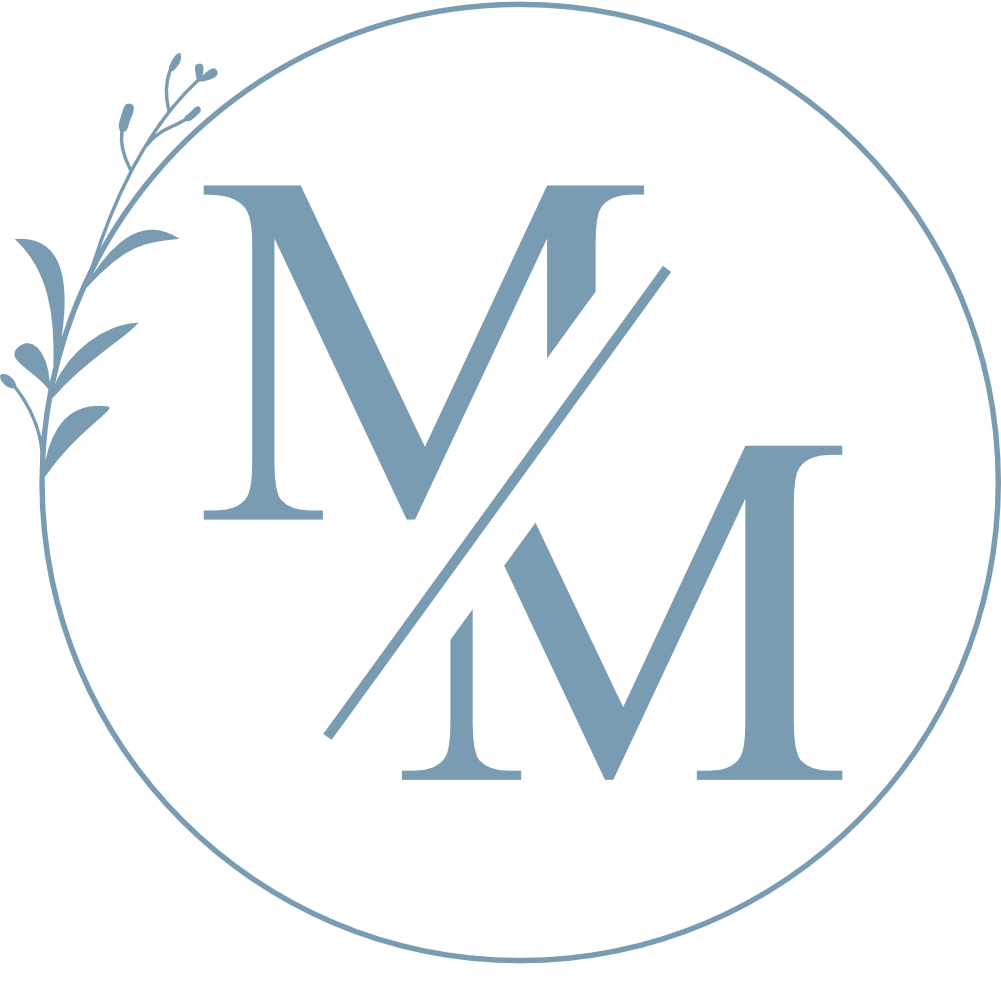 Blue monogram “MM” inside a thin blue circle with a leafy branch accent on the left