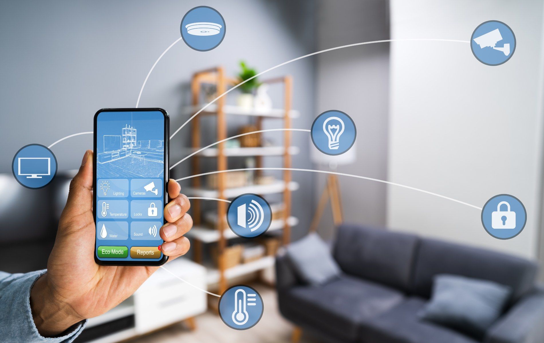 Person holding smartphone controlling smart home devices in a living room.