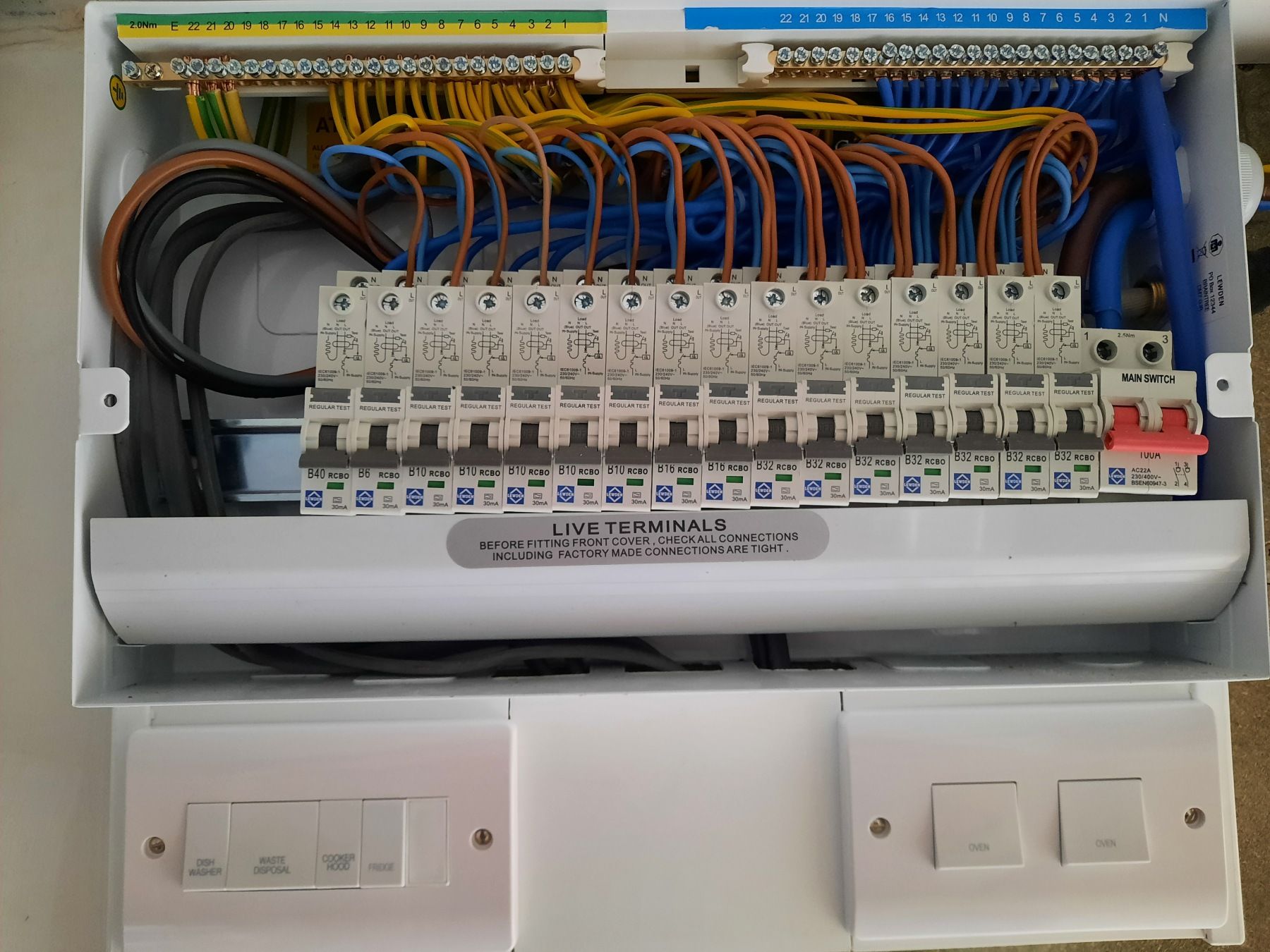 Electrical panel with numerous colored wires and circuit breakers.