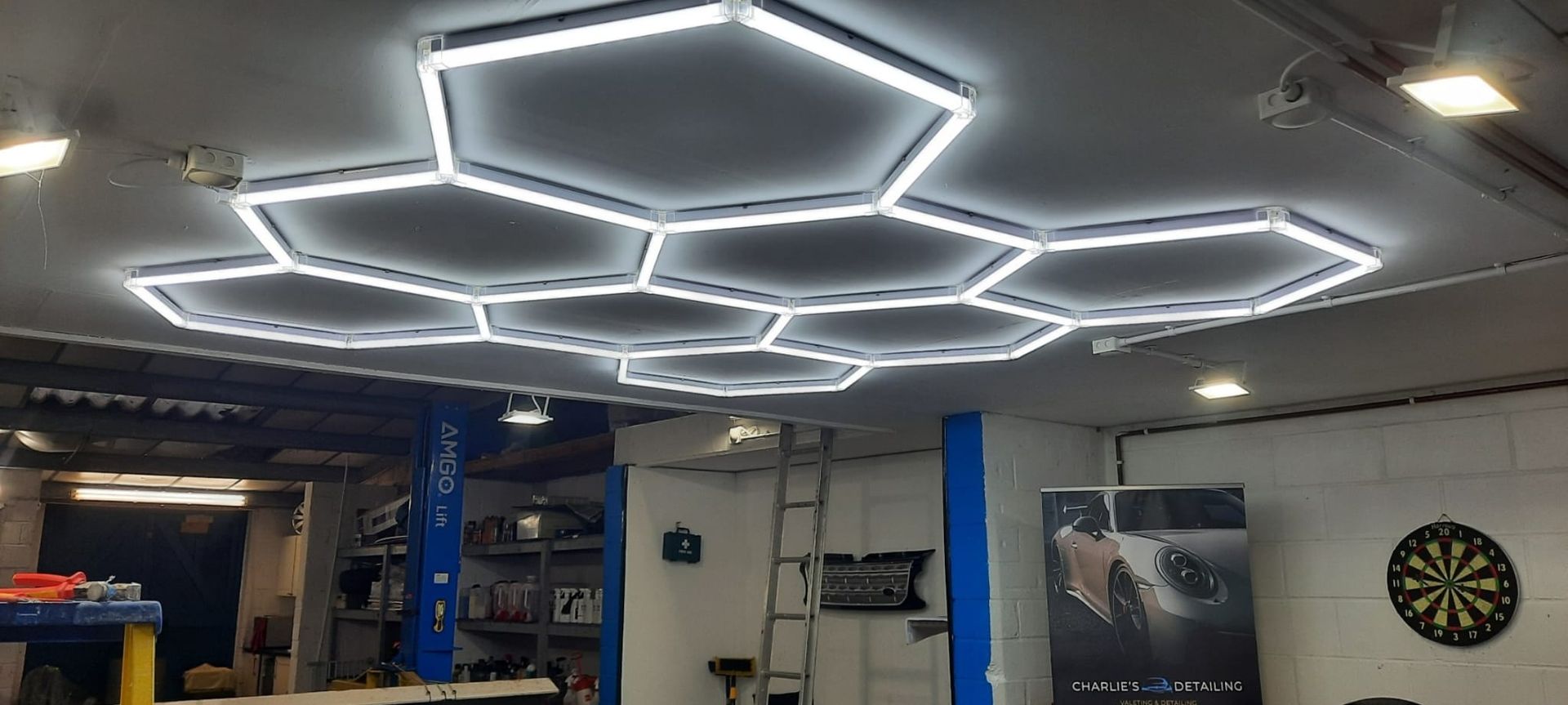 A garage ceiling featuring a large, glowing, honeycomb-shaped LED light fixture.