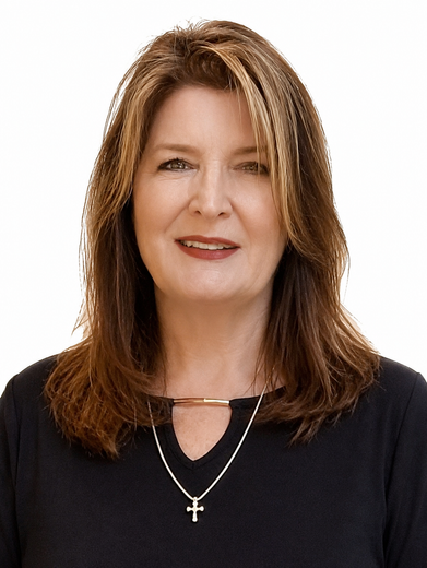 Portrait of a smiling woman with shoulder-length brown hair wearing a black top and silver cross necklace on white background