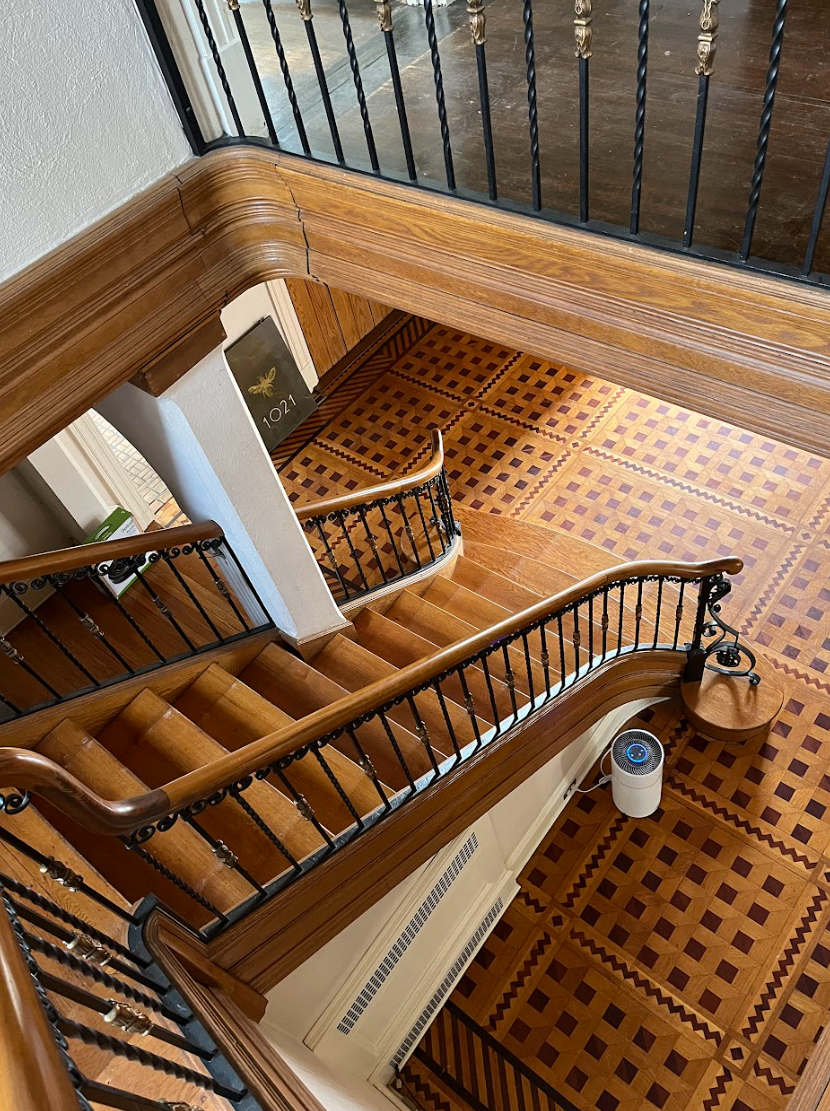 An aerial view of a wooden staircase with a wrought iron railing.